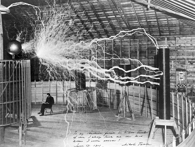 Una de las fotos más míticas de Tesla en el laboratorio de Colorado Springs donde realizaba sus experimentos de recepción a larga distancia. La imagen la tomó el fotógrafo Dickenson Alley mediante exposición múltiple. Vía: Wikipedia